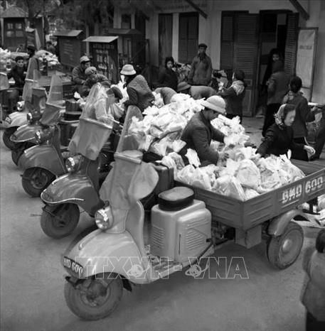 Trong ảnh: Công ty Bách hóa Bán lẻ Hà Nội tổ chức đóng gói hàng Tết đúng tiêu chuẩn định lượng và điều vận tốt hàng hóa đến bán tại các cửa hàng bách hóa và các quầy hàng tập thể ở cơ quan, xí nghiệp, phục vụ nhân dân trong dịp Tết Canh Tuất 1970. Ảnh: Trần Phác - TTXVN