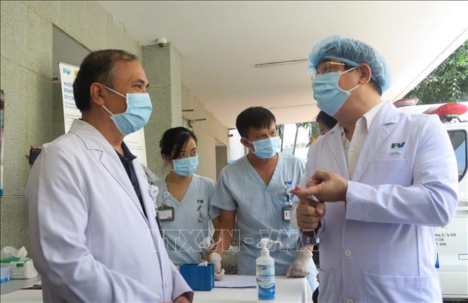Trong ảnh: Cục trưởng Cục Quản lý Khám chữa bệnh Lương Ngọc Khuê trao đổi với bác sỹ Bệnh viện FV. Ảnh: Đinh Hằng – TTXVN                               