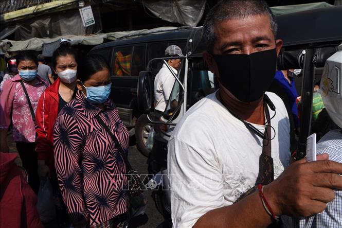 Trong ảnh: Người dân đeo khẩu trang phòng lây nhiễm COVID-19 tại Phnom Penh, Campuchia, ngày 14/3. Ảnh: AFP/TTXVN