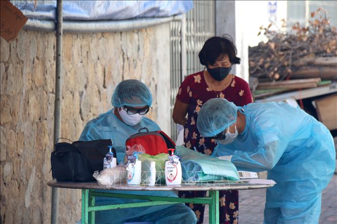 Photo: Locals in quarantined areas in the central province of Binh Thuan get daily medical check-ups and temperature measurement. VNA Photo: Nguyễn Thanh