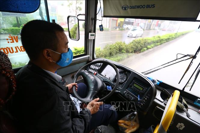 Trong ảnh: Người lái xe và phụ xe buýt cũng thực hiện nghiêm việc đeo khẩu trang khi làm việc. Ảnh: Minh Quyết - TTXVN

 
