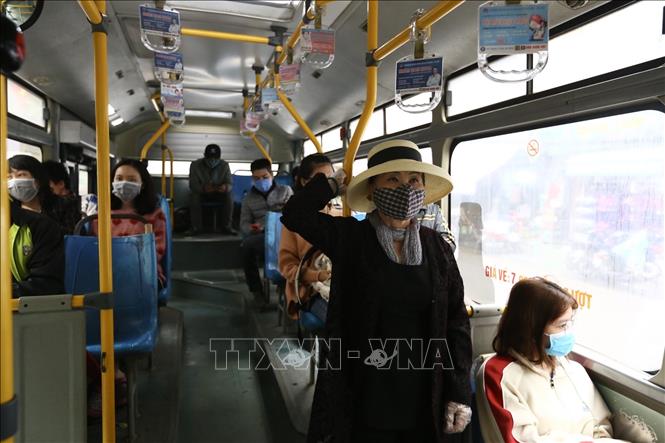 Trong ảnh: Hành khách thực hiện đeo khẩu trang khi tham gia giao thông trên xe buýt công cộng. Ảnh: Minh Quyết - TTXVN