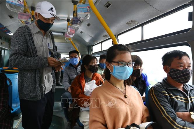 Trong ảnh: Lái xe và phụ xe buýt thực hiện nghiêm việc đeo khẩu trang khi làm việc. Ảnh: Minh Quyết - TTXVN

 