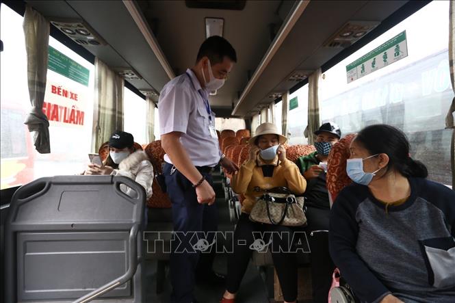 Trong ảnh: Lái xe buýt nhắc nhở người tham gia giao thông đeo khẩu trang. Ảnh: Minh Quyết - TTXVN