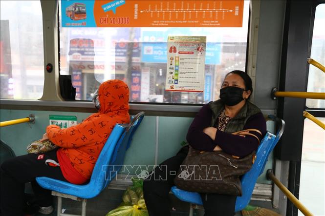 Trong ảnh: Hành khách thực hiện đeo khẩu trang khi tham gia giao thông trên xe buýt công cộng. Ảnh: Minh Quyết - TTXVN