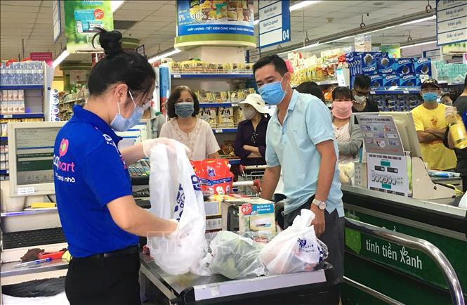 Photo: Customers shopping in Coopmart supermarket in Ho Chi Minh City wear facial masks as required. VNA Photo: Thanh Vũ