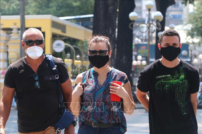 Photo: Foreign tourists to HCM City wear facial masks as required. VNA Photo: Thanh Vũ
