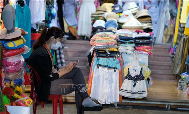 Trong ảnh: Nhân viên một cửa hàng bán đồ lưu niệm trong khu phố Tây Nha Trang ngồi thảnh thơi khi không có khách đến mua sắm. Ảnh: Nguyễn Dũng - TTXVN