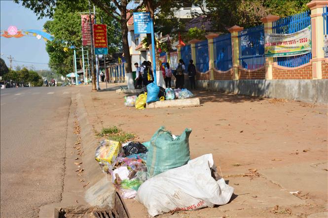 Trong ảnh: Rác thải ngay trạm xe buýt và gần cổng trường học. Ảnh: Hoài Thu – TTXVN