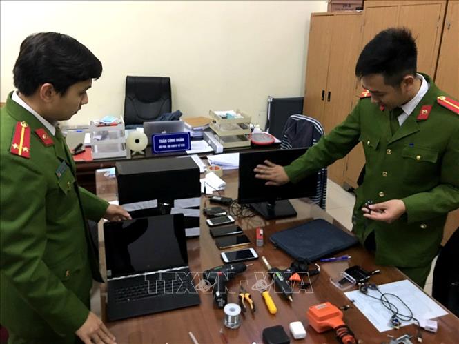 Trong ảnh: Cảnh sát kiểm tra các thiết bị có lắp camera siêu nhỏ của các đối tượng tại cơ quan công an. Ảnh: Doãn Tấn - TTXVN