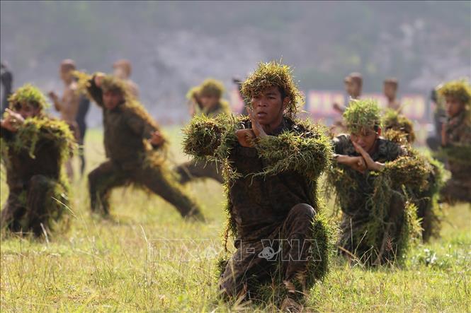 Trong ảnh: Chiến sĩ đặc công huấn luyện võ thuật và kỹ thuật ngụy trang. Ảnh: Dương Giang - TTXVN