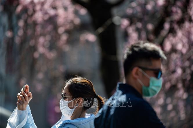 Trong ảnh: Du khách đeo khẩu trang phòng tránh lây nhiễm COVID-19 tại Tokyo, Nhật Bản, ngày 12/3/2020. Ảnh: AFP/ TTXVN