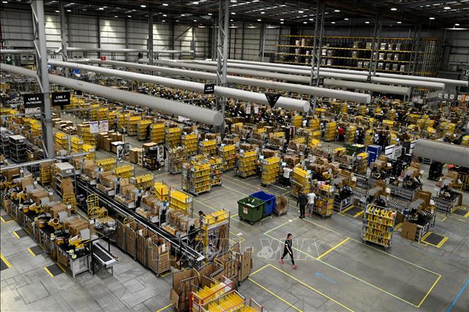 Trong ảnh (tư liệu): Công nhân phân loại và đóng gói hàng hóa tại kho hàng của Amazon ở Peterborough, Anh. Ảnh: AFP/TTXVN