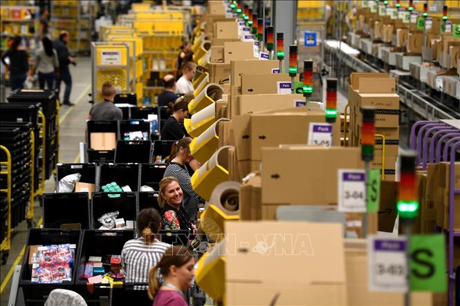 Trong ảnh (tư liệu): Công nhân phân loại và đóng gói hàng hóa bên tại kho hàng của Amazon ở Peterborough, Anh. Ảnh: AFP/TTXVN