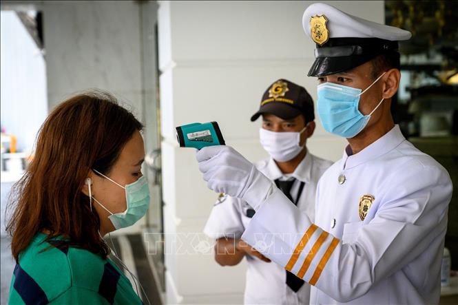 Trong ảnh: Nhân viên an ninh kiểm tra thân nhiệt người dân nhằm ngăn dịch COVID-19 lây lan tại một tòa nhà ở Bangkok, Thái Lan ngày 16/3/2020. Ảnh: AFP/TTXVN