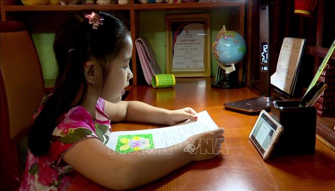 Trong ảnh: Các em học sinh Trường tiểu học Chu Văn An, thành phố Đồng Hới, Quảng Bình được kết nối với thầy cô, bạn bè, để ôn tập online. Ảnh: TTXVN

