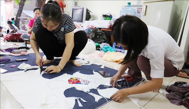 Trong ảnh: Phụ nữ Thành phố Hồ Chí Minh may khẩu trang tặng miễn phí cho người nghèo. Ảnh: TTXVN

