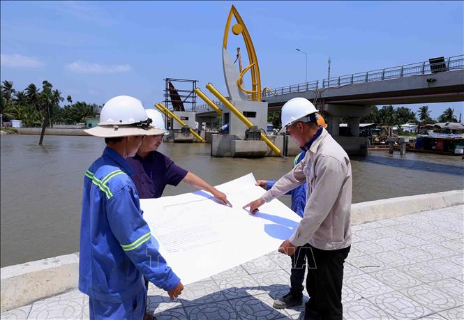 Trong ảnh: Các kỹ sư và ban quản lý Dự án triển khai thực hiện thi công hạng mục cuối cùng Dự án Cống Vũng liêm kết hợp cầu giao thông (Huyện Vũng Liêm, tỉnh Vĩnh Long) thuộc Dự án Hệ thống thủy lợi Nam Mang Thít. Ảnh: Vũ Sinh - TTXVN