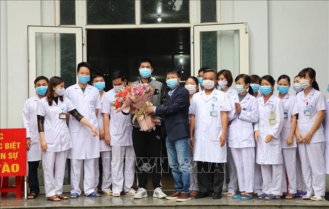 Giám đốc Trung tâm kiểm soát bệnh tật tỉnh Ninh Bình chúc mừng bệnh nhân được xuất viện. Ảnh: Đức Phương - TTXVN