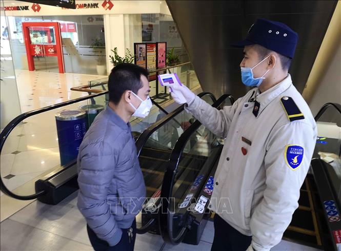 Trong ảnh: Đo thân nhiệt cho khách vào trung tâm thương mại để phòng chống dịch COVID-19. Ảnh: Thanh Tùng-TTXVN
