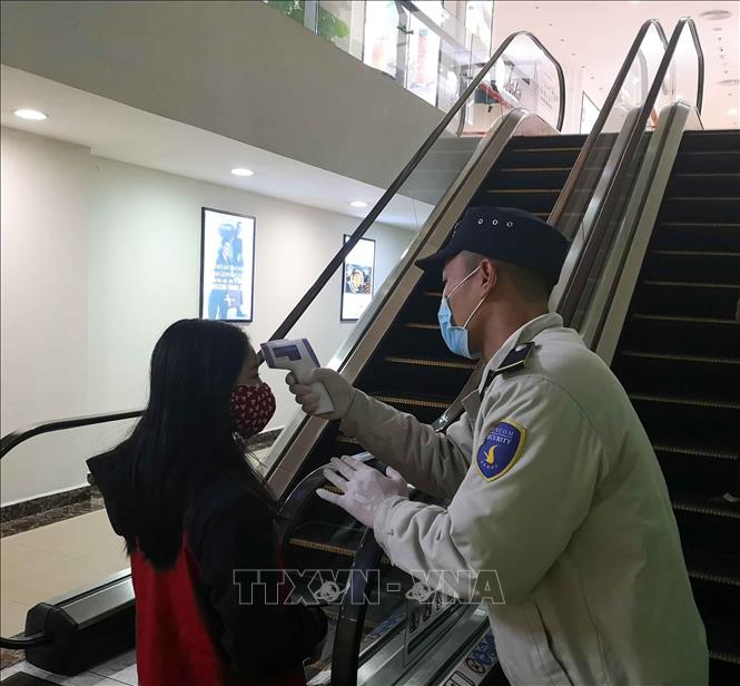 Trong ảnh: Đo thân nhiệt cho khách vào trung tâm thương mại để phòng chống dịch COVID-19. Ảnh: Thanh Tùng-TTXVN