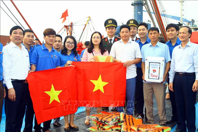 Trong ảnh: Ban Thường vụ Tỉnh đoàn Nghệ An cùng đại diện lãnh đạo tỉnh Nghệ An tặng 500 cờ Tổ quốc cùng 200 áo phao cho các ngư dân trẻ vươn khơi bám biển (3/1/2020). Ảnh: Tá Chuyên - TTXVN