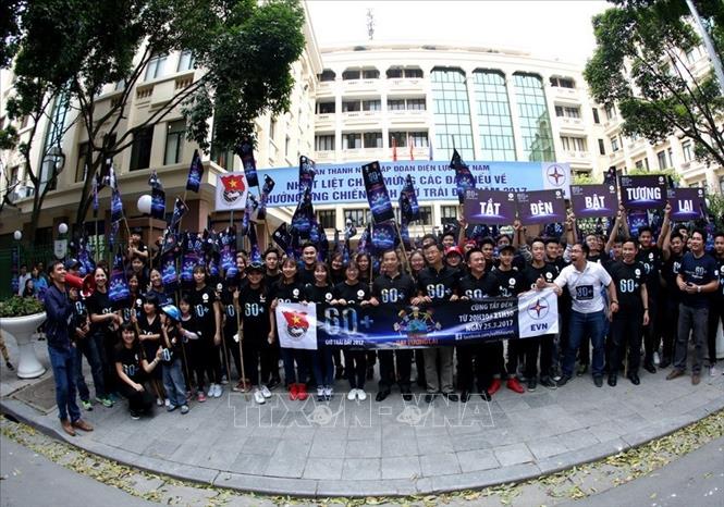 Trong ảnh: Đoàn Thanh niên Tập đoàn Điện lực Việt Nam và sinh viên tình nguyện trường Đại học Điện lực diễu hành quanh hồ Hoàn Kiếm hưởng ứng Chiến dịch Giờ Trái đất năm 2017 . Ảnh: Ngọc Hà - TTXVN