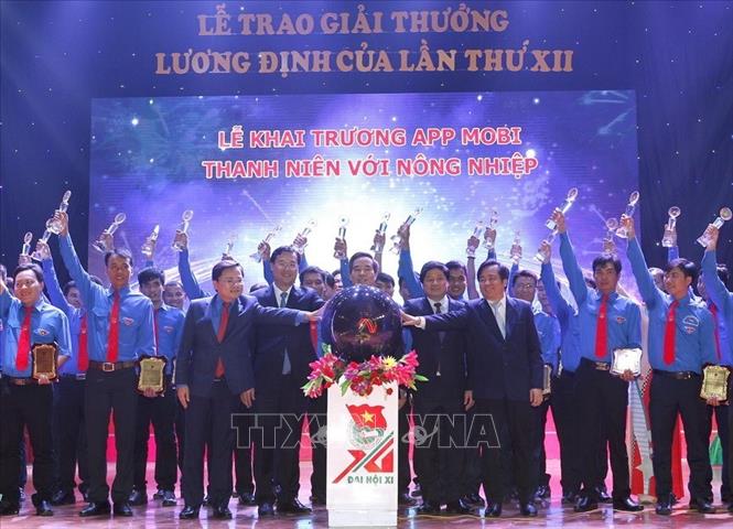Trong ảnh: Tại lễ trao Giải thưởng Lương Định Của lần thứ XII, các đại biểu nhấn nút khai trương ứng dụng điện thoại thông minh để chuyển giao tiến bộ khoa học kỹ thuật cho thanh niên và nhân dân (30/11/2007). Ảnh: Văn Điệp – TTXVN