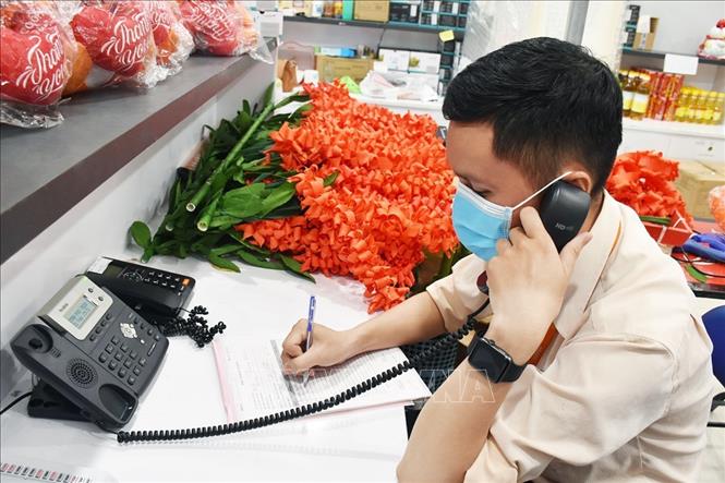 Trong ảnh: Nhân viên Saigon Co.op nhận đơn đặt hàng qua điện thoại. Ảnh: TTXVN phát