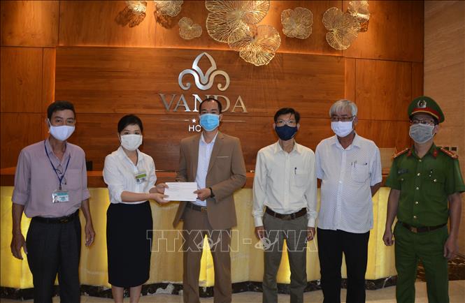 Trong ảnh: Đại diện phòng Y tế quận Hải Châu trao giấy hoàn thành cách ly cho đại diện khách sạn Vanda. Ảnh: Văn Dũng - TTXVN