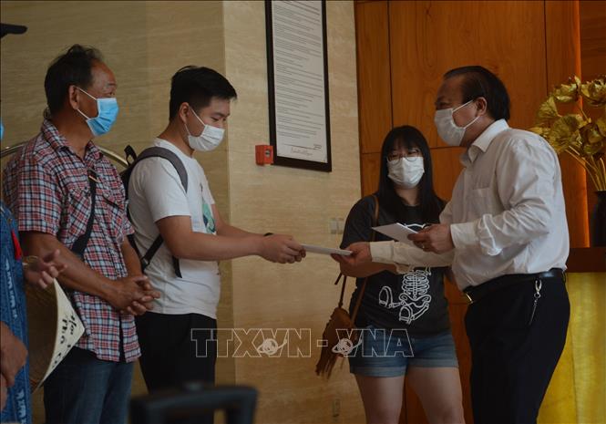 Trong ảnh: Chủ tịch UBND quận Hải Châu Lê Anh phát giấy chứng nhận hoàn thành cách ly y tế cho các khách cách ly tại khách sạn. Ảnh: Văn Dũng - TTXVN