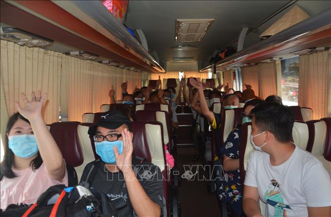 Trong ảnh: Du khách hoàn thành cách ly chào tạm biệt, chuẩn bị ra sân bay trở về nước. Ảnh: Văn Dũng - TTXVN