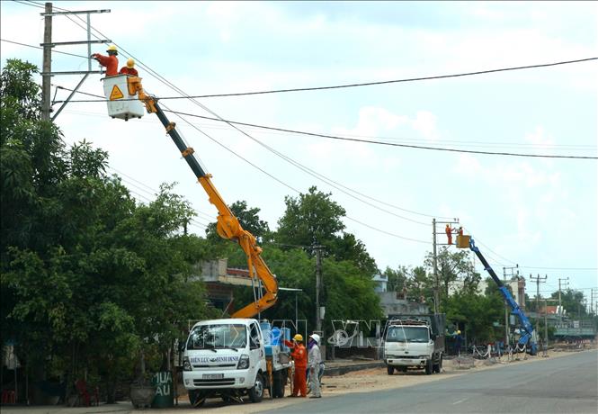 Trong ảnh: Công nhân Công ty Điện lực Quảng Ngãi di dời, cải tạo lưới điện thuộc Dự án mở rộng Quốc lộ 1A. Ảnh: Ngọc Hà - TTXVN