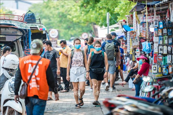 Trong ảnh: Người dân đeo khẩu trang nhằm ngăn chặn sự lây lan của dịch COVID-19 tại thủ đô Viêng Chăn, Lào ngày 23/3/2020. Ảnh: THX/TTXVN