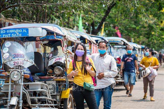 Trong ảnh: Người dân đeo khẩu trang nhằm ngăn chặn sự lây lan của dịch COVID-19 tại thủ đô Viêng Chăn, Lào ngày 23/3/2020. Ảnh: THX/TTXVN