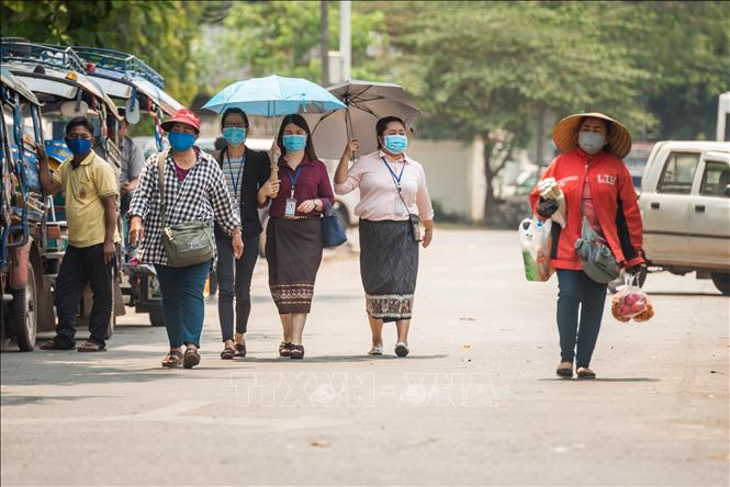 Trong ảnh: Người dân đeo khẩu trang nhằm ngăn chặn sự lây lan của dịch COVID-19 tại thủ đô Viêng Chăn, Lào ngày 23/3/2020. Ảnh: THX/TTXVN