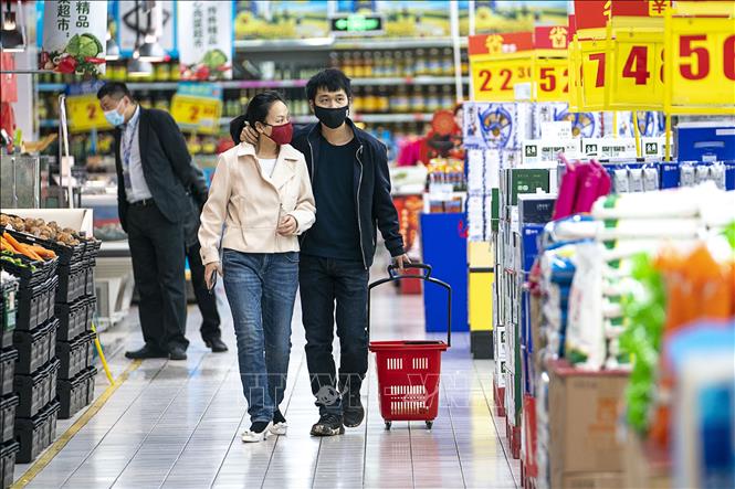 Trong ảnh: Người dân đeo khẩu trang để phòng tránh lây nhiễm COVID-19 tại siêu thị ở Vũ Hán, tỉnh Hồ Bắc, Trung Quốc, ngày 24/3/2020. Ảnh: THX/TTXVN