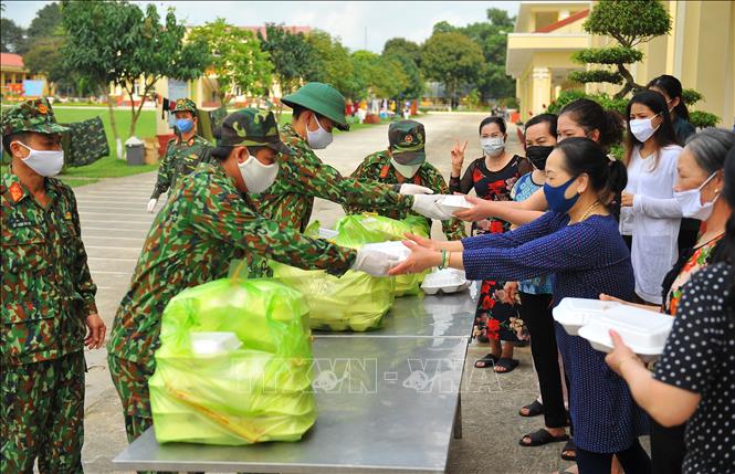 Trong ảnh: Đều đặn ngày 3 bữa, đúng giờ, các chiến sĩ Trường Quân sự Quân đoàn 1 trao những suất cơm cho các công dân. Ảnh: Minh Đức - TTXVN