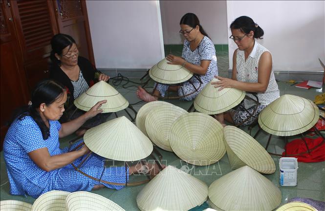 Trong ảnh: Làng Mỹ Lam thuộc xã Phú Mỹ, huyện Phú Vang (Thừa Thiên - Huế) có nghề chằm nón lá lâu đời với 80% số hộ trong làng làm nghề, phục vụ du lịch, lễ hội và thị hiếu của khách hàng. Ảnh: Hồ Cầu - TTXVN