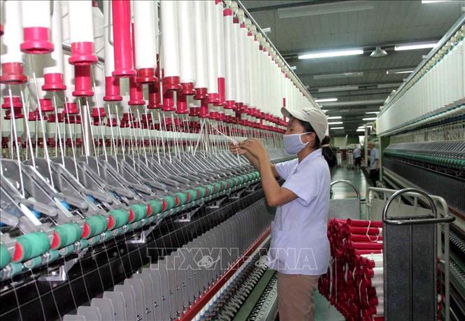 Trong ảnh: Công nhân làm việc tại nhà máy sợi Huế thuộc Công ty Cổ phần Dệt may Huế (Thừa Thiên - Huế). Ảnh: Quốc Việt - TTXVN
