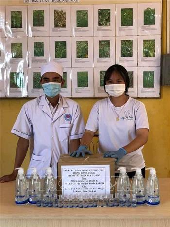 Trong ảnh: Nhóm từ thiện phát nước rửa tay cho các cơ sở y tế địa phương. Ảnh: Hồng Điệp -TTXVN
