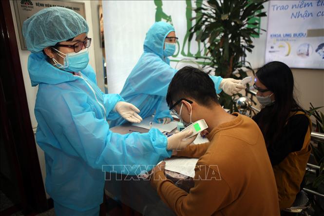 Trong ảnh: Tất cả bệnh nhân đến Bệnh viện Đa khoa Hồng Ngọc đều được đo thân nhiệt ở trán và cổ, nhằm phát hiện người có biểu hiện sốt để phân luồng khám. Ảnh: Danh Lam – TTXVN
