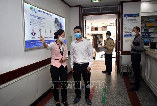 Trong ảnh: Nhân viên y tế bệnh viện Đa khoa Hồng Ngọc tận tình hướng dẫn bệnh nhân đi đúng phòng khám. Ảnh: Danh Lam – TTXVN