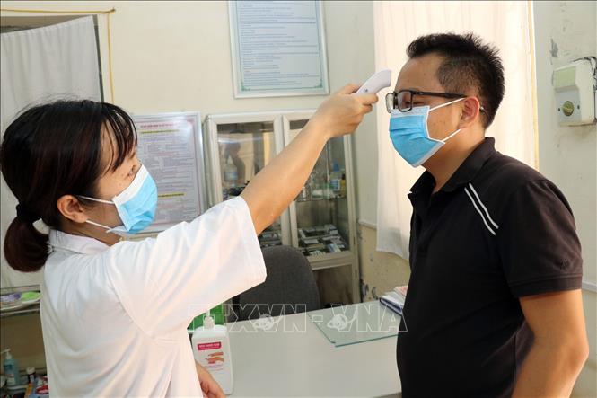 Trong ảnh: Tất cả mọi người khi ra vào Cơ sở Sơn Tây - Trường Đại học Lao động - Xã hội đều phải kiểm tra thân nhiệt. Ảnh: Anh Tuấn - TTXVN