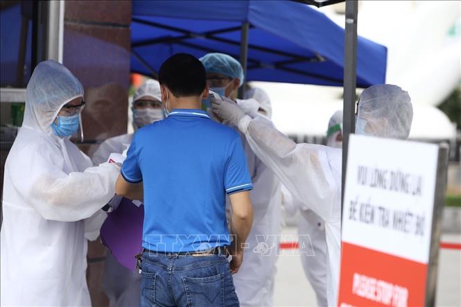 Trong ảnh: Khu vực cổng số 1 Bệnh viện Bạch Mai luôn có đội ngũ y tế trực đo thân nhiệt và sát khuẩn tay cho người dân. Ảnh: Minh Quyết - TTXVN