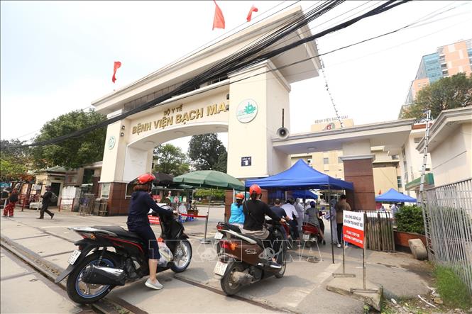Trong ảnh: Tại cổng số 1 Bệnh viện Bạch Mai mọi hoạt động vẫn bình thường, người dân khi vào cổng sẽ được đo kiểm tra thân nhiệt và sát khuẩn tay. Ảnh: Minh Quyết - TTXVN