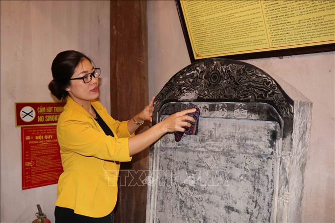 Trong ảnh: Cán bộ Ban Quản lý di tích Văn miếu thường xuyên lau chùi các bia Tiến sĩ. Ảnh: Thanh Thương - TTXVN
