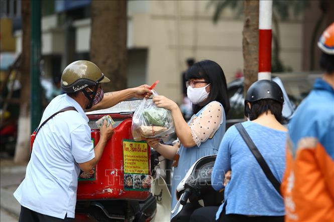 Trong ảnh: Shipper giao hàng cho khách. Ảnh: Minh Quyết - TTXVN