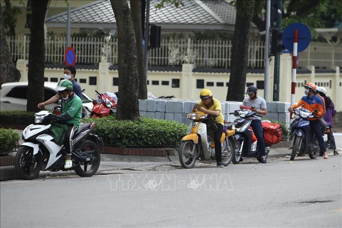 Trong ảnh: Shiper đứng xếp hàng, chờ giao hàng cho khách. Ảnh: Minh Quyết - TTXVN
