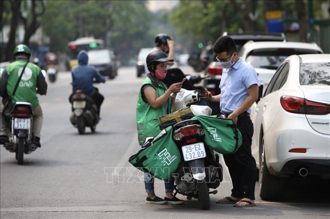 Trong ảnh: Shiper giao hàng cho khách. Ảnh: Minh Quyết - TTXVN